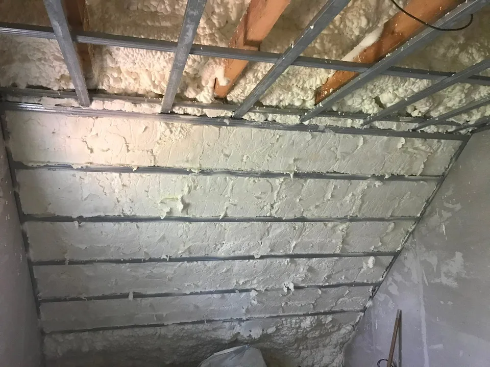 Detail nastříkané PUR pěny mezi dřevěnými prvky konstrukce