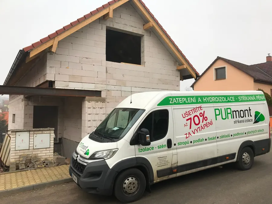 Dodávka PURmont u hrubé stavby rodinného domu s rozestavěným štítem a krovem